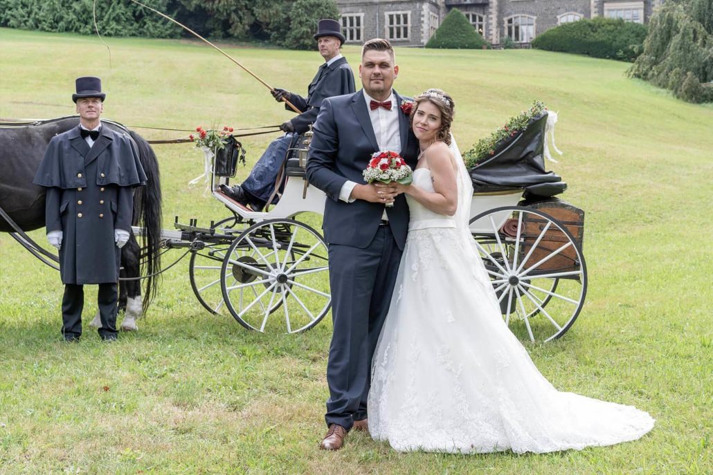 Brautpaar mit Hochzeitskutsche im Park vor dem Schloss Rauischholzhausen