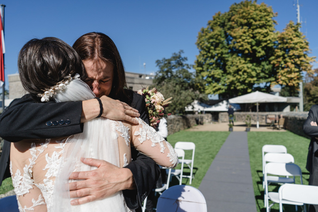 Mutter umarmt ganz fest ihre Tochter nach der Eheschließung