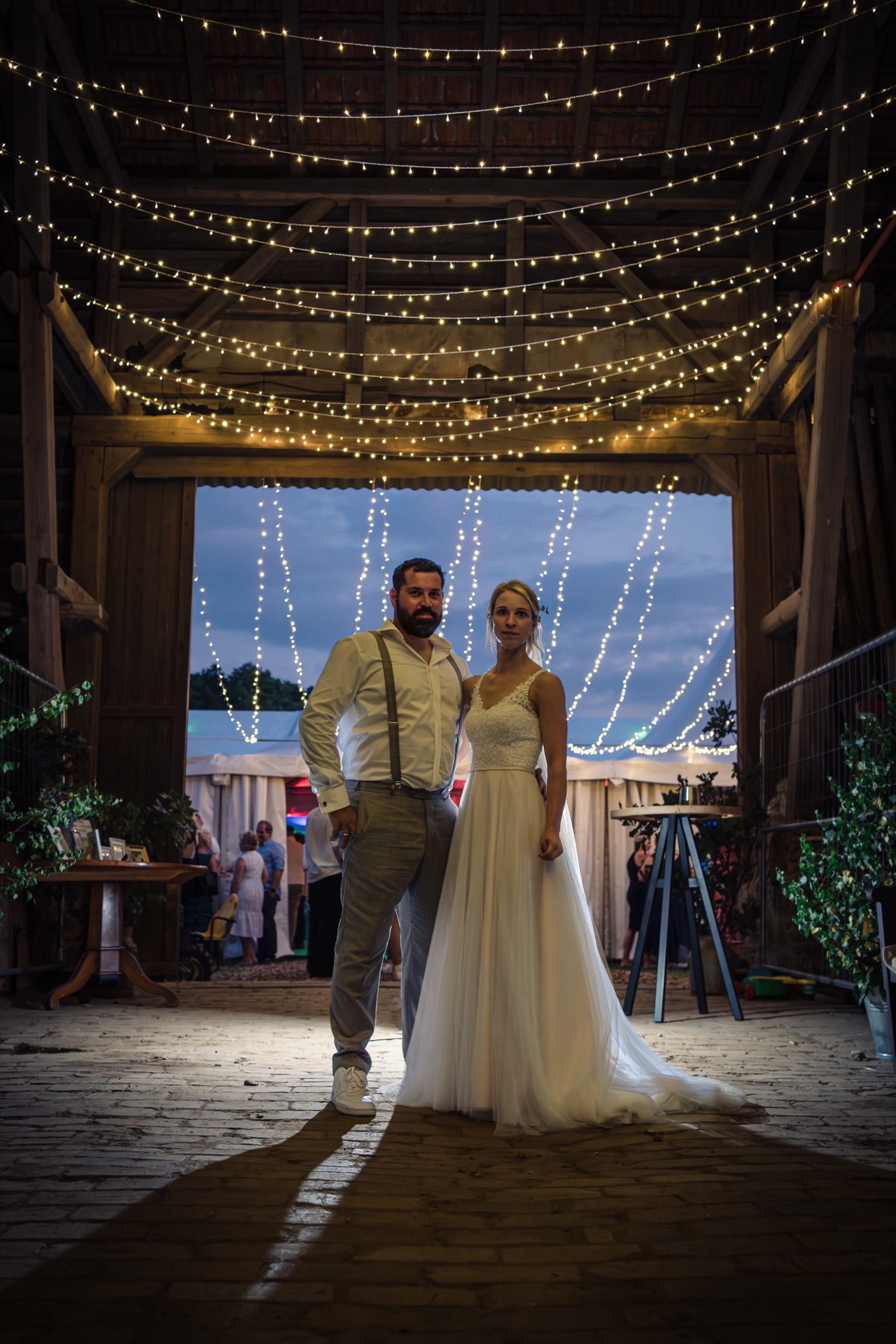 Brautpaar mit Lichterkette vor dem Eingang zur Hochzeitsfeier