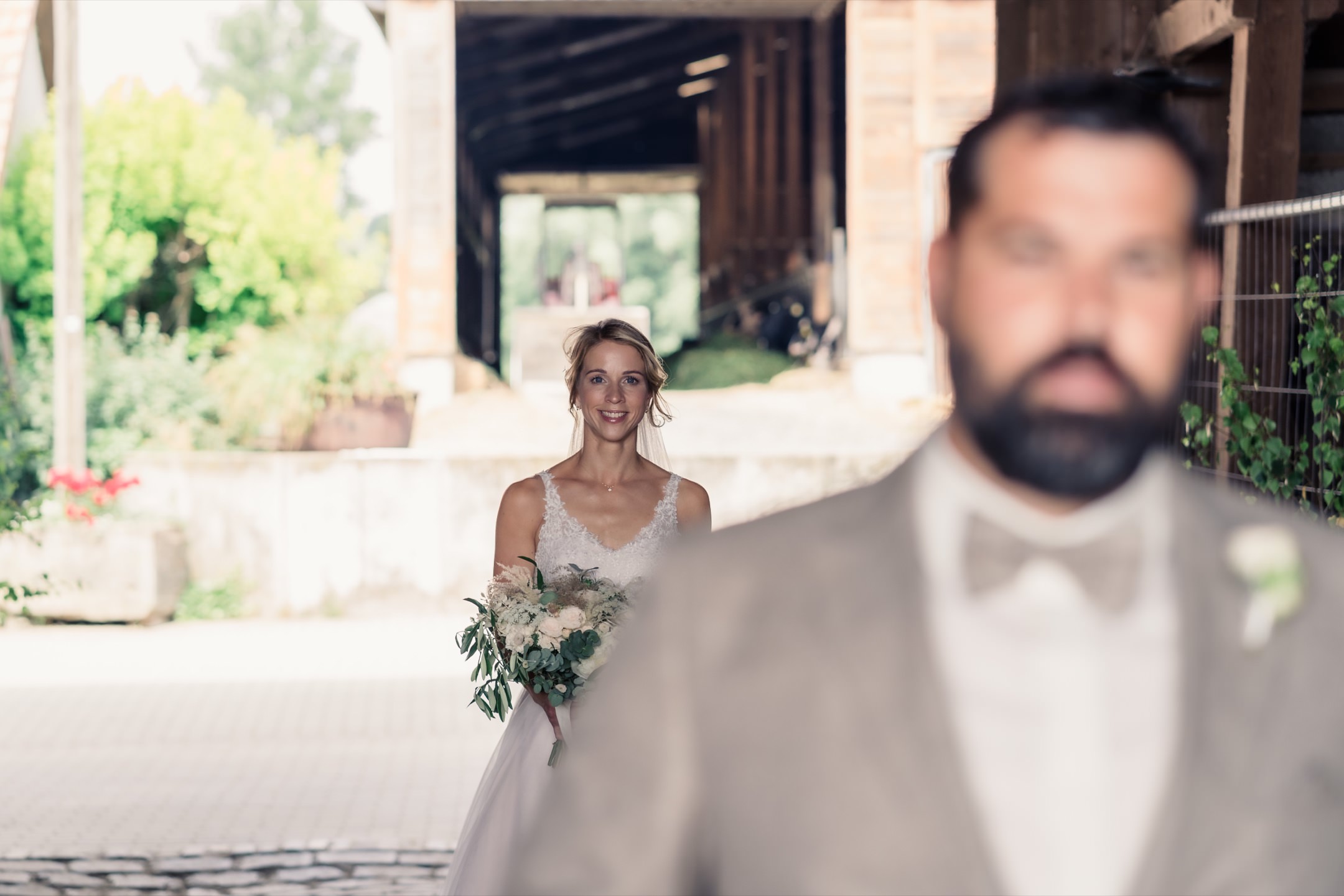 Sommerhochzeit Firstlook-Shooting: Kathrin steht hinter ihrem Bräutigam