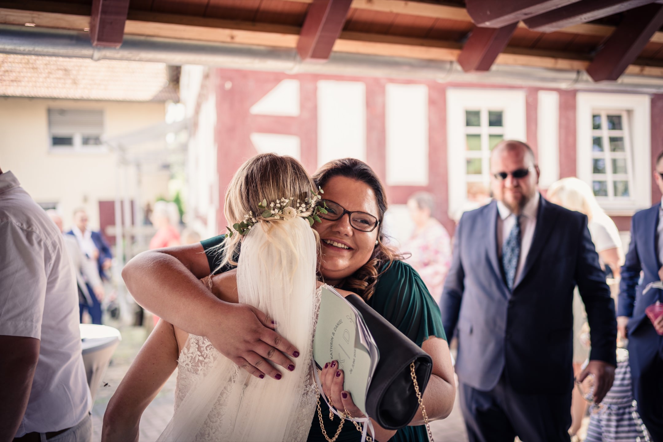 Hochzeitsgast umarmt die Braut bei den Gratulationen